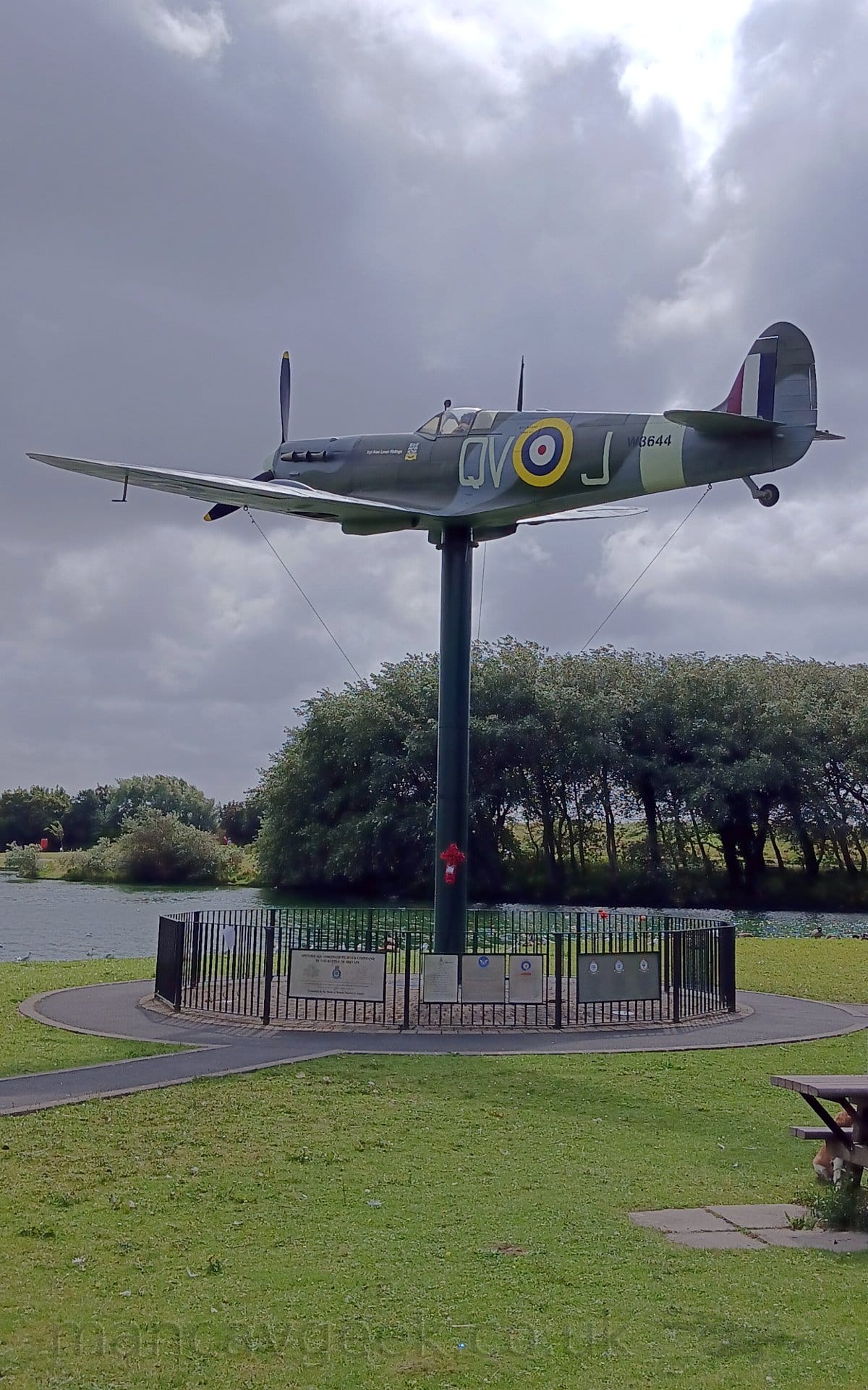 On This Day 18th August 2024. W3644, Supermarine Spitfire Mk.Vb (Replica), in Royal Air Force markings, mounted on a pole at the Fylde Spitfire Memorial, Fairhaven Lake, Lytham St Annes. This is one of many Spitfires scattered around the Blackpool area, including Spitfire Island, and the Spitfire Visitor Centre at Blackpool Airport.
