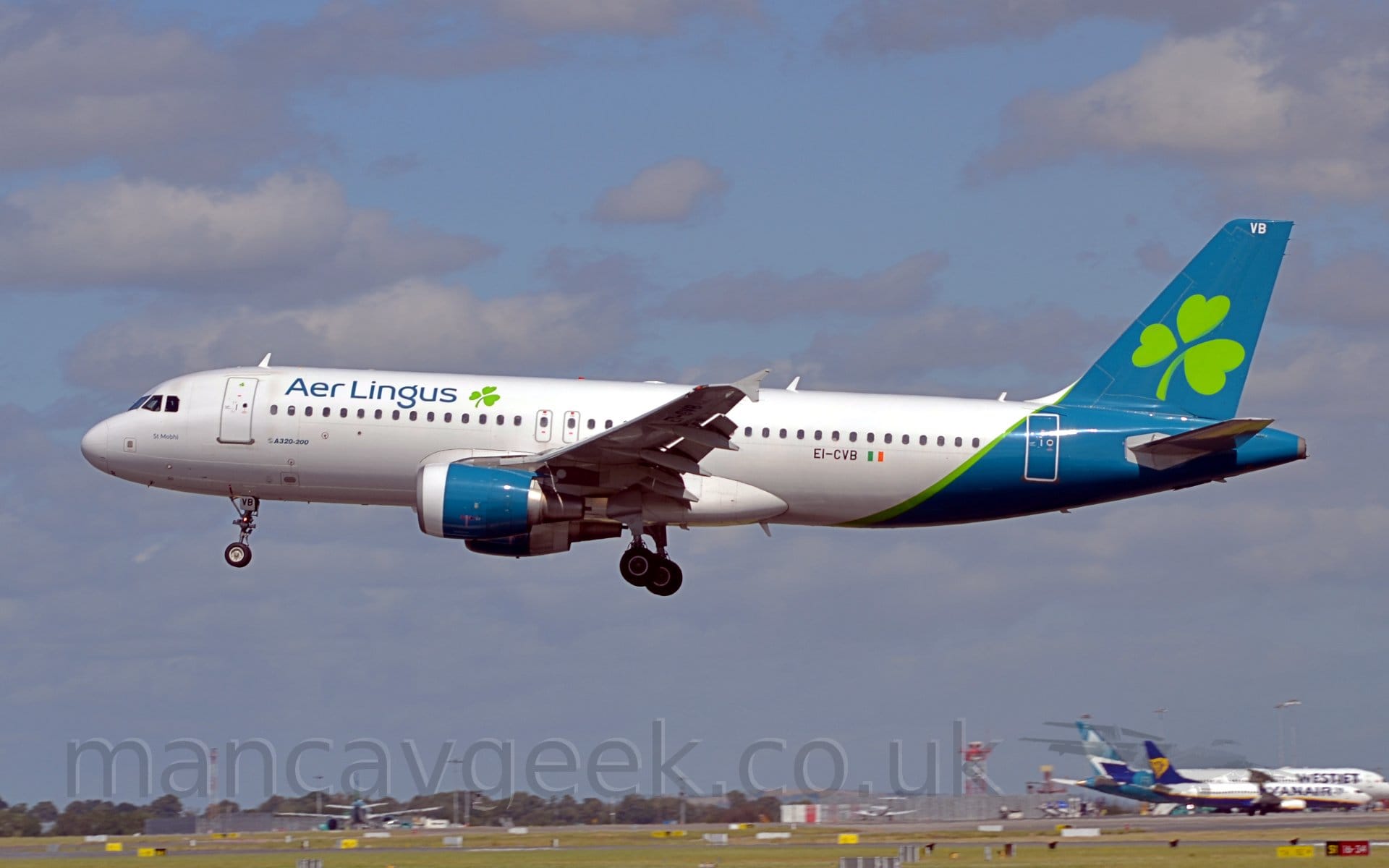 Side view of a white, twin engined jet airliner flying from right to left at a very low leve