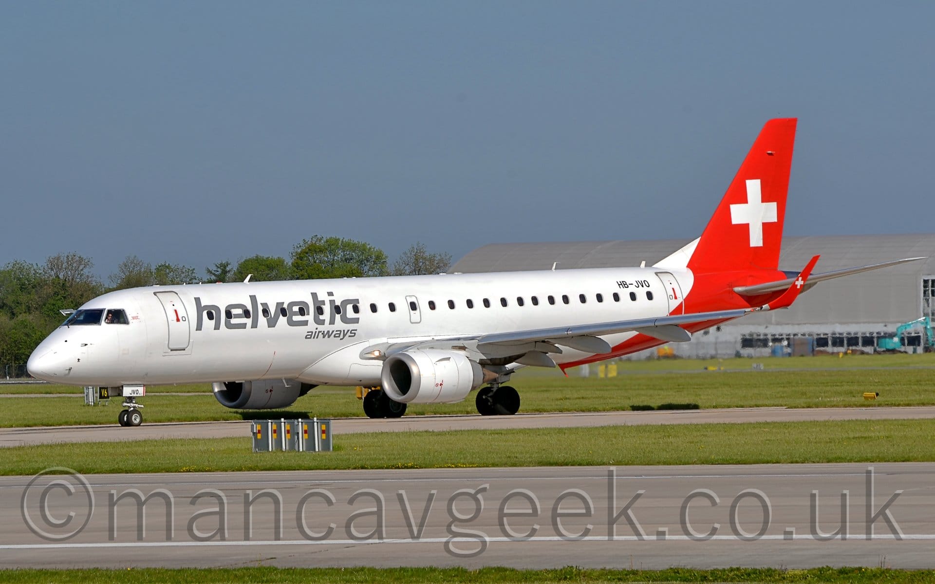 Side view of a twin engined jet airliner taxiing from right to left on a taxiway.