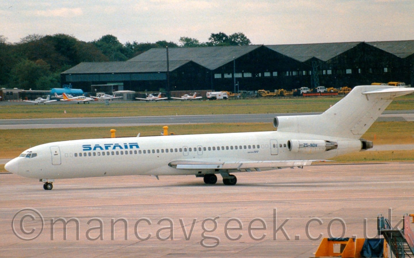 Side view of a 3 engined jet airliner taxiing from right to left.
