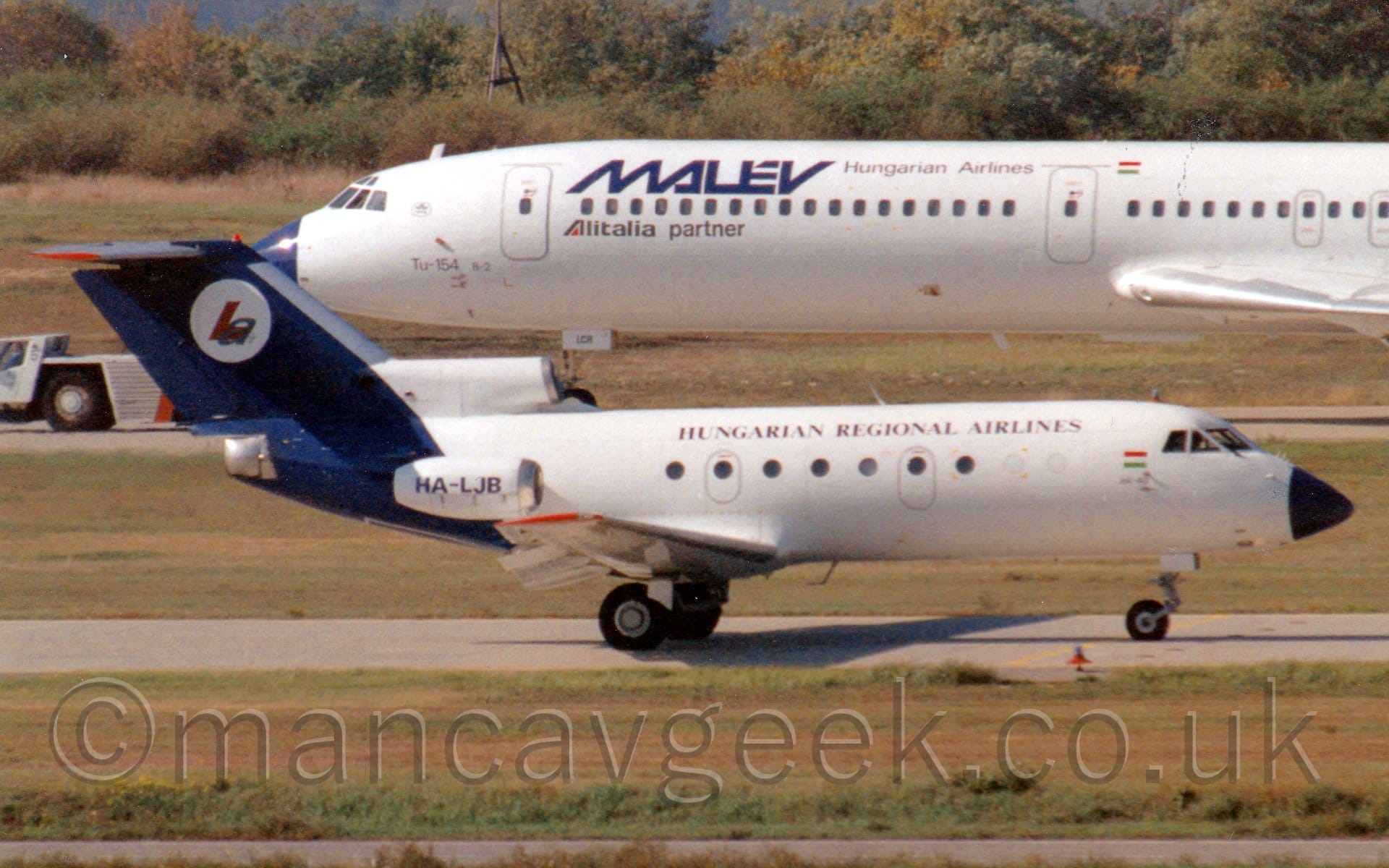 Side view of a 3 engined jet airliner with the engines mounted on the rear of the fuselage, taxiing from left to right.