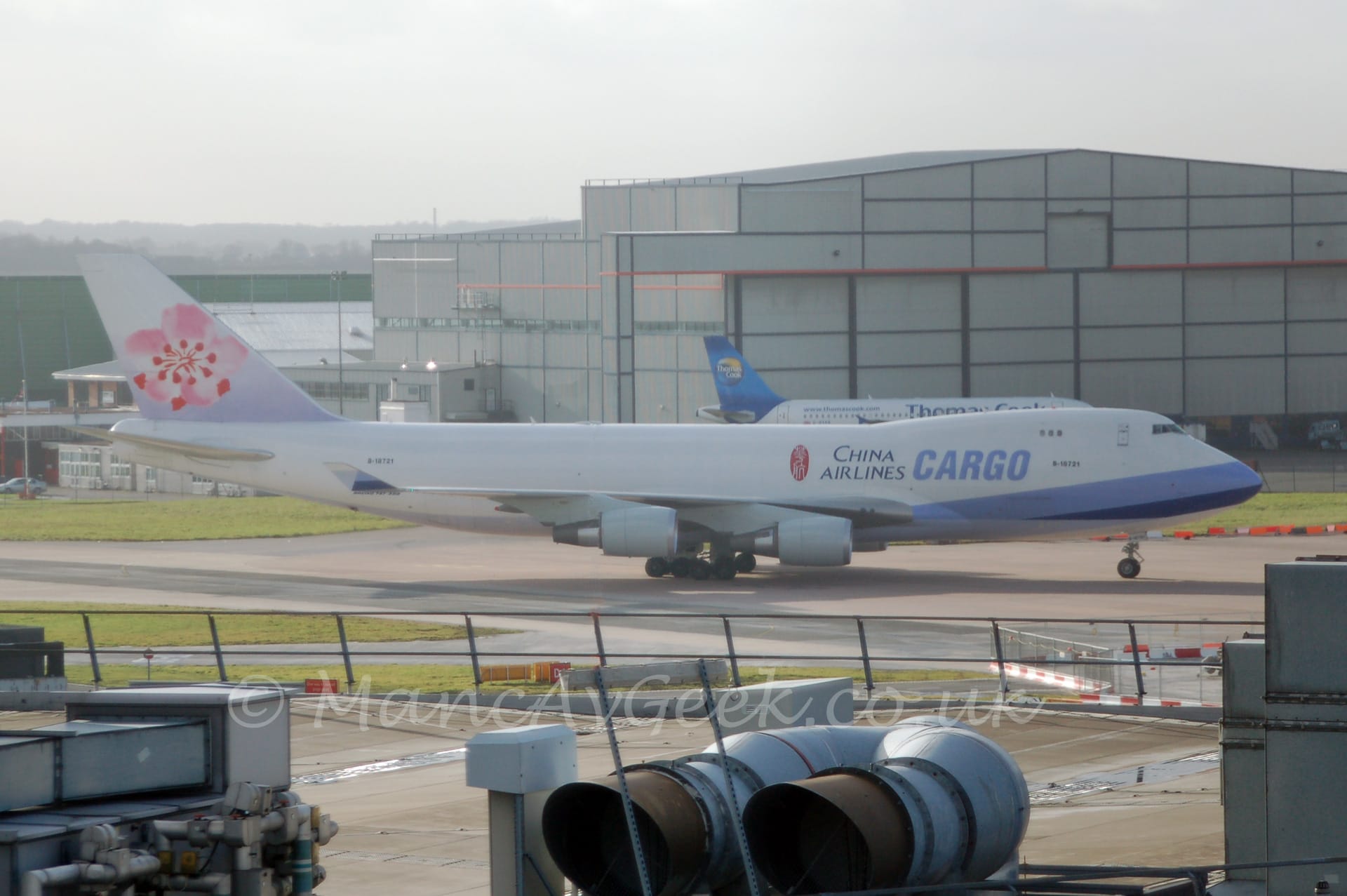 Side view of a very large, 4 engined jet airliner taxiing from left to right.