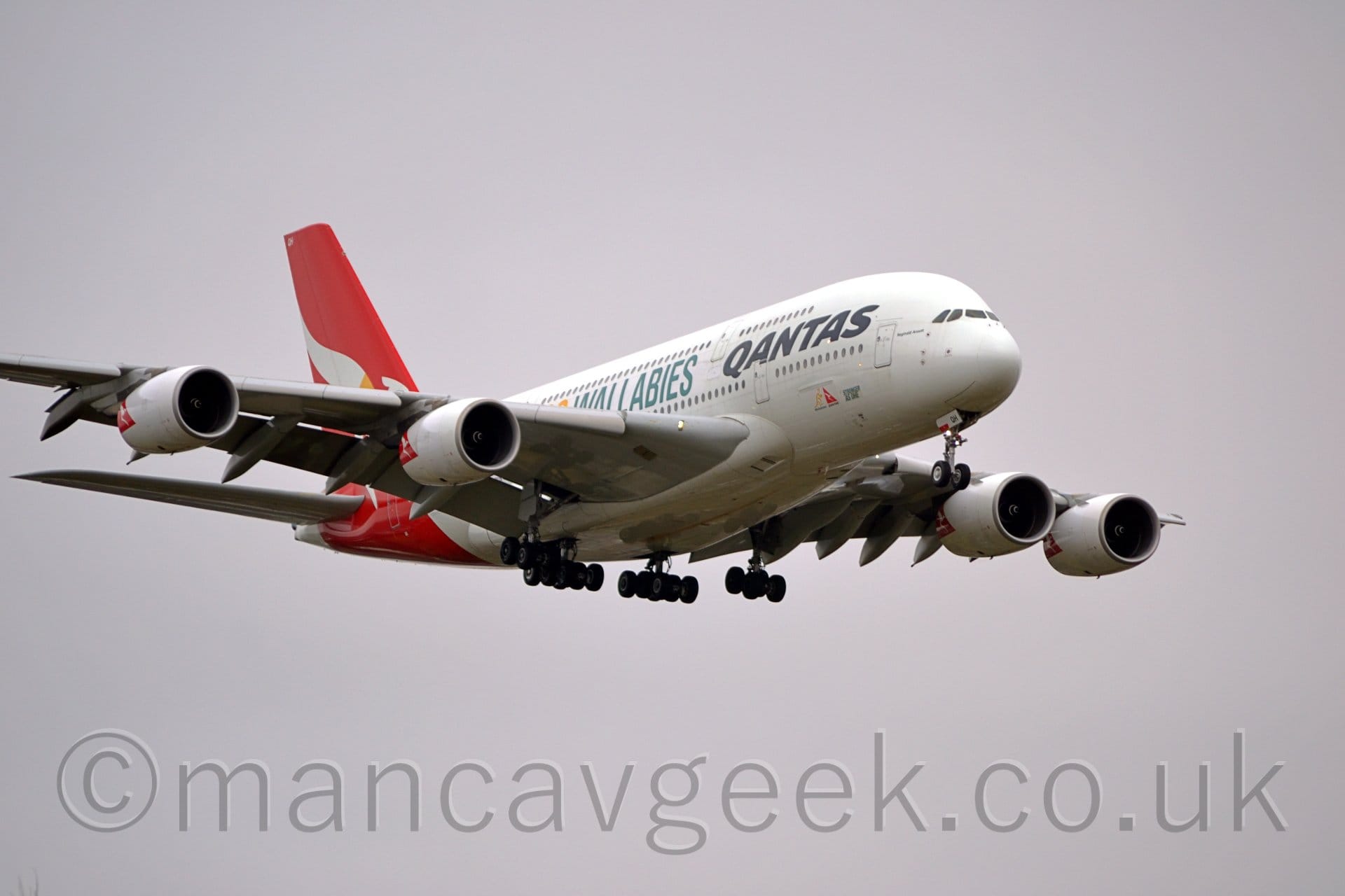 Low side view of a very large, 4 engined jet airliner flying from left to right at a low altitude