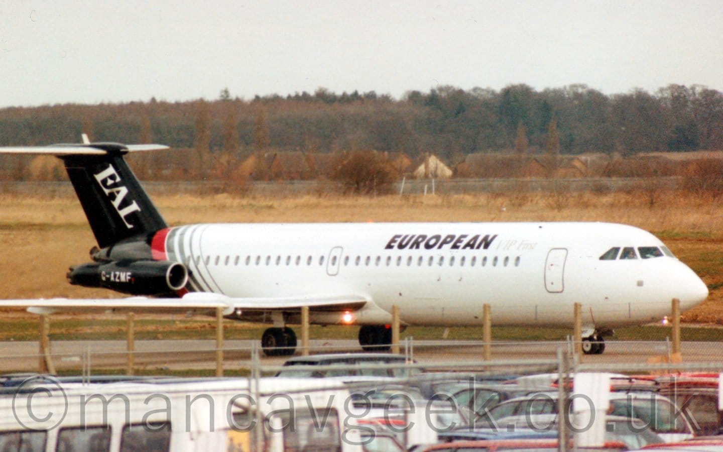 Side view of a twin engined airliner with the engines mounted on the sides of the rear fuselage, taxiing from left to right.