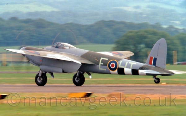 Side view of a World War 2-era twin propellor-engined military fighter-bomber during it's take-off run.