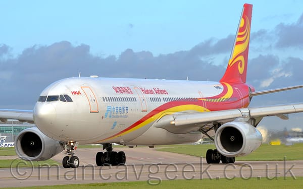 Side view of a white, twin engined jet airliner taxiing from right to left.