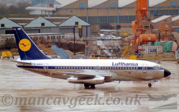 Side view of a white, twin engined jet airliner taxiing from left to right.