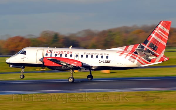 Side view of a white, twin propellor-engined airliner  just leaving a black runway, moving from right to left, it's nosewheel in the air,