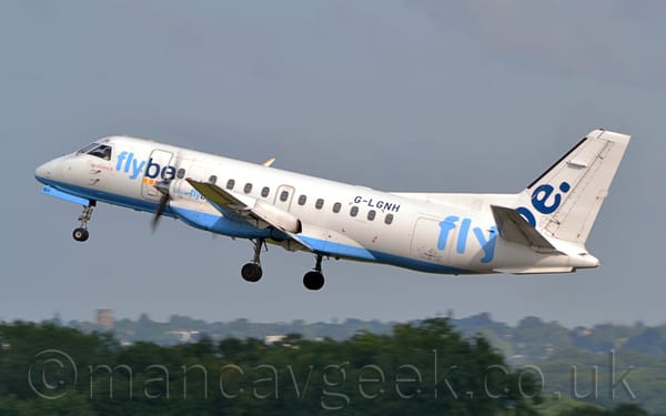 Side view of a white, twin propellor-engined airliner flying from right to left.