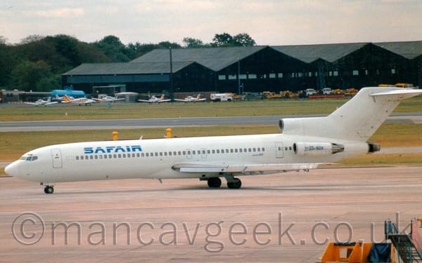 Side view of a 3 engined jet airliner taxiing from right to left.