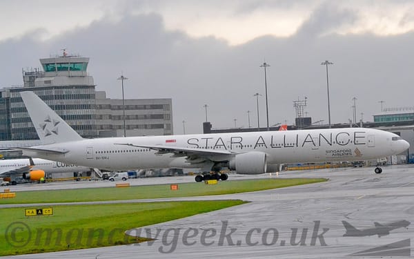Side view of a twin engined jet airliner taxiing from left to right.