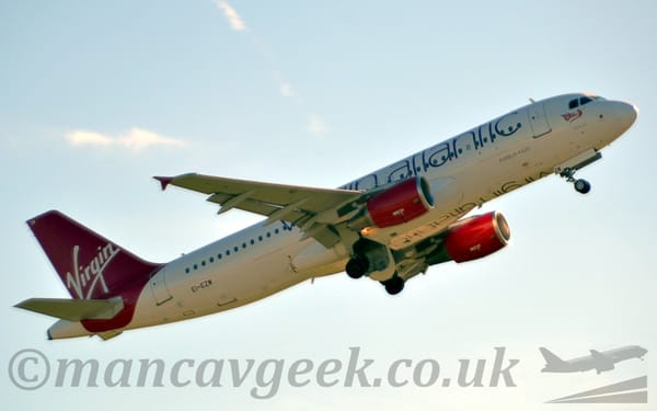 Side view of a twin engined jet airliner flying from left to right at a very low altitude