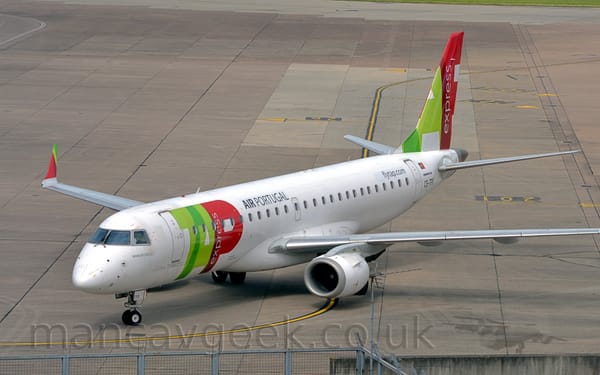 Slightly elevated side view of a white, twin-engined jet airliner taxiing from right to left.