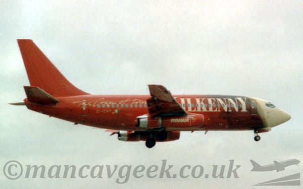 Side view of a twin engined jet airliner flying from left to right at a very low altitude.