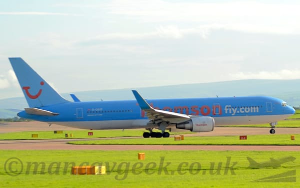 Side view of a twin engined jet airliner taxiing from left to right.