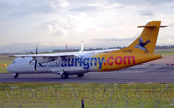 Side view of a high-winged, twin propellor-engined airliner taxiing from right to left.