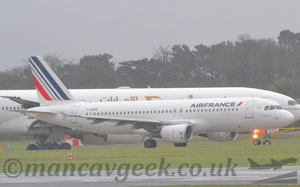 Side view of a twin engined jet airliner taxiing from left to right.