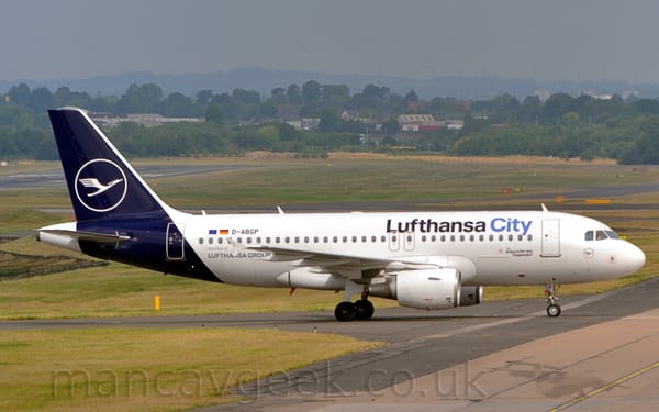 Side view of a twin engined jet airliner taxiing from left to right.
