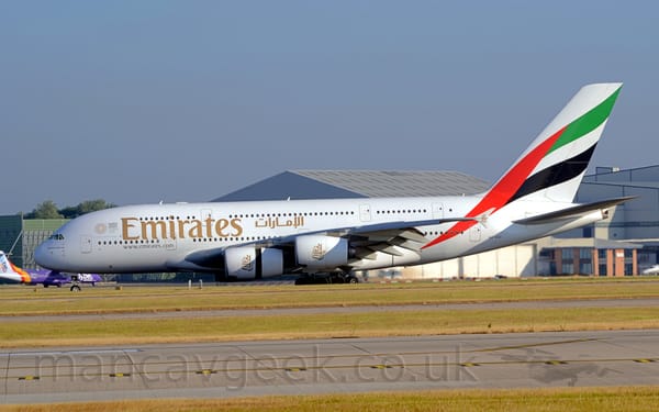 Side view of a very large, 4 engined jet airliner moving from right to left along a runway
