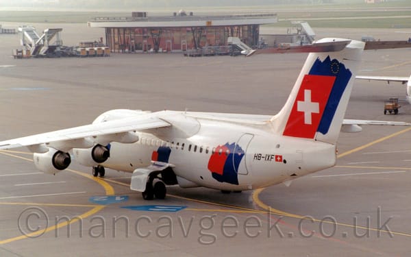 Rear side view of a high-winged, 4 engined jet airliner taxing from right to left.