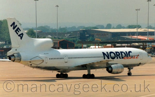 Side view of a 3 engined  jet airliner taxiing from left to right.