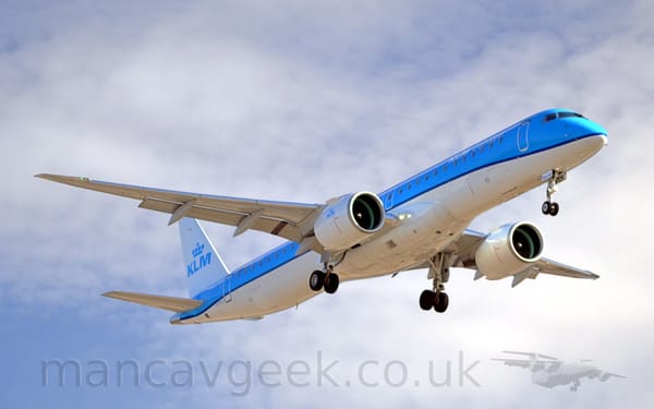 Low side view of a twin engined jet airliner flying from left to right at a very low altitude
