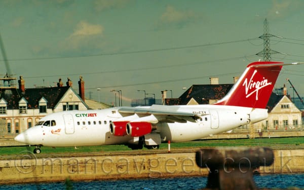 Side view of a white, high-winged, 4 engined jet airliner decelerating as it moves from right to left.
