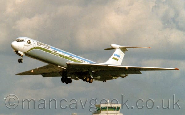 Side view of a 4 engined jet airliner with the engines mounted in pairs  on the rear fuselage, flying from left to right at a low altitude