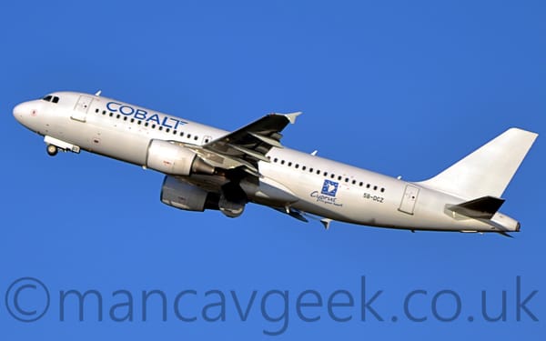 Side view of a white, twin engined jet airliner flying from right to left at a low altitude.