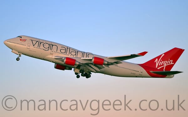 Side view of a very large, 4 engined jet airliner flying from right to left at a low altitude