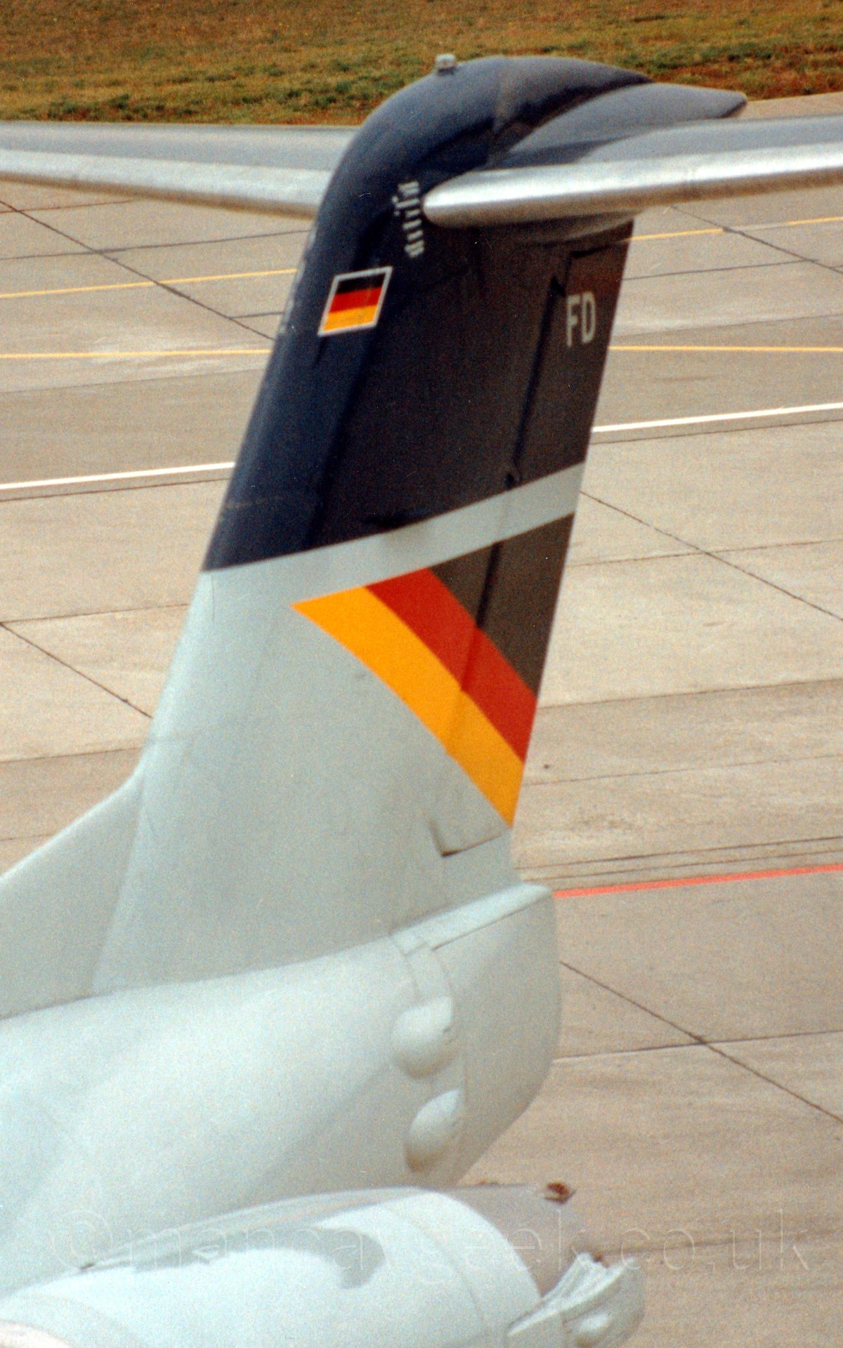 Close up of the grey and black tail oif a jet airliner, parked facing to the left.