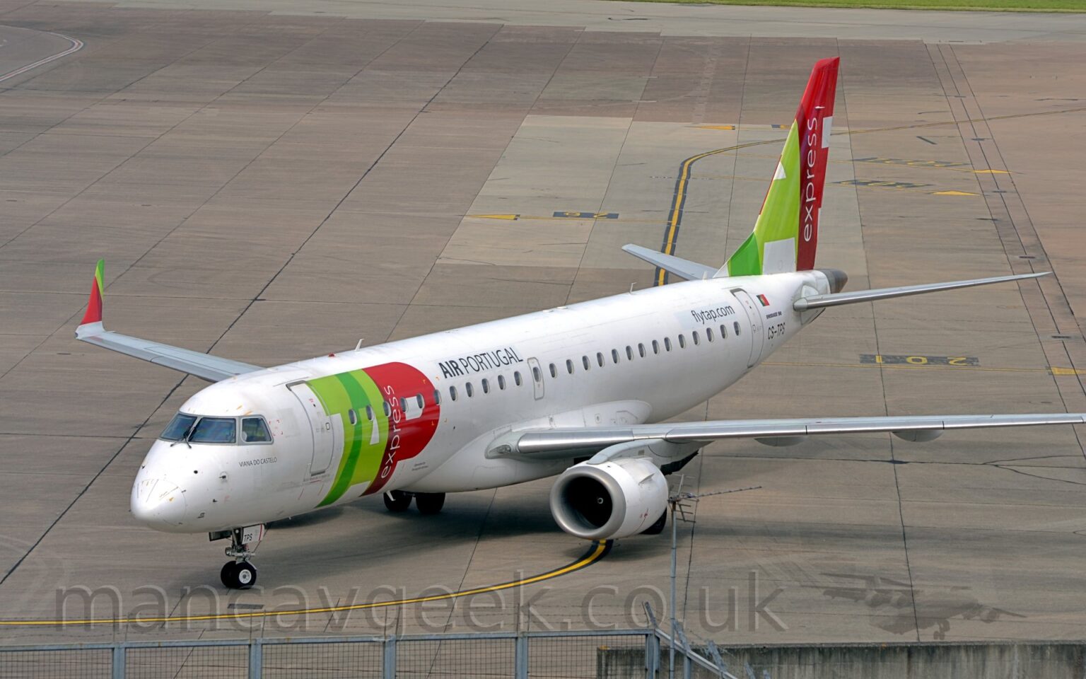 Slightly elevated side view of a twin-engined jet airliner taxiing from right to left. The plane is mostly white, with billboard-style, red and green "TAP" titles on the side of the forward fuselage, with smaller "Air Portugal " titles above the windows at the front of the passenger cabin. The tail has part of those same large red and green titles, with white "Express" titles arranged vertically in the long stroke of the red letter "P". Grey concrete apron marked with lines for planes to follow fills the rest of the frame.